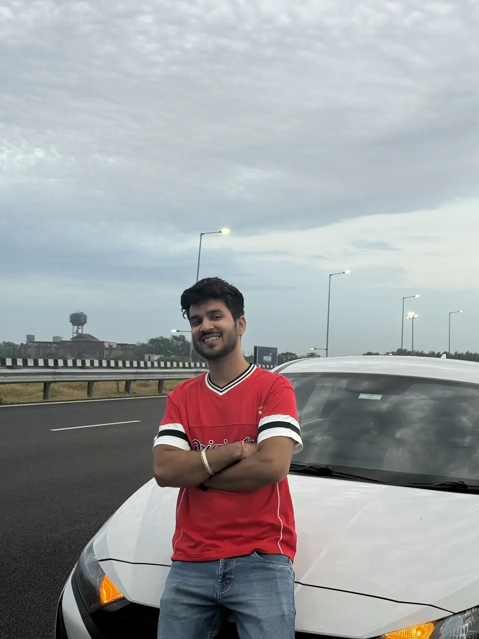 Pritish Bhatti smiling in a red t-shirt outdoors