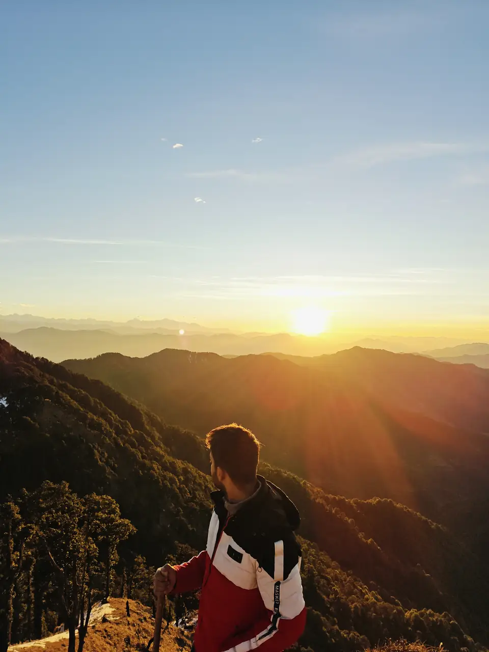 Pritish Bhatti from behind, watching the sun set over Himalayan ridgelines
