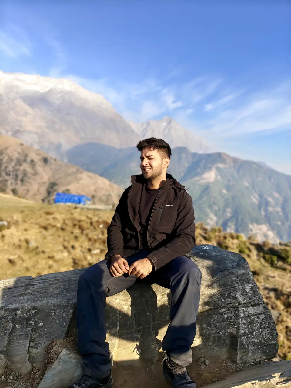 Pritish Bhatti grinning on a mountain trail at dusk